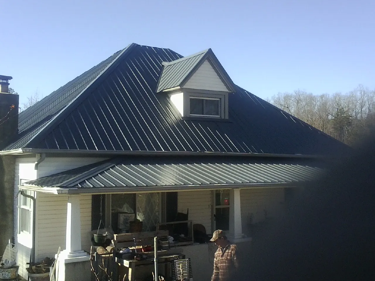 Dark blue standing seam metal roof with a dormer above a front porch in Victorville