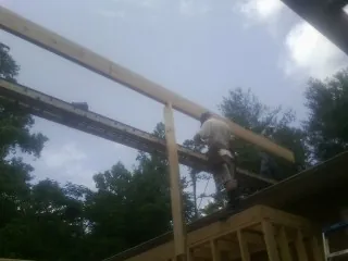 Carpenter setting a ridge beam over a new addition frame — Ice Dam Removal by Roofing Brothers in Victorville